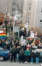 Crowd of protesters holding signs on a city street in Chicago.