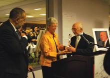 cathy knight presents award to Greg Dell as Gilbert Caldwell looks on. 