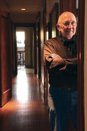 Greg Dell standing in a doorway in a long hallway.